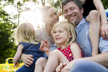Glückliche Eltern und drei Töchter beim Familienpicknick im Park - CUF12968