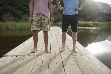 Waist down front view of young men on wooden pier, Cala Luna, Sardinia, Italy - CUF13042