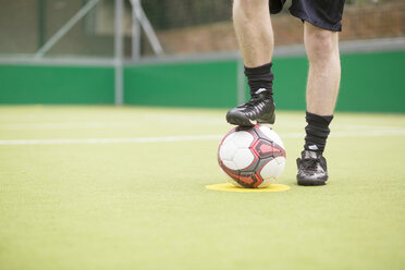 Junger Mann auf städtischem Fußballplatz, Fuß auf Fußball, niedriger Ausschnitt - CUF13048