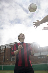 Two young men playing with football on urban football pitch - CUF13051