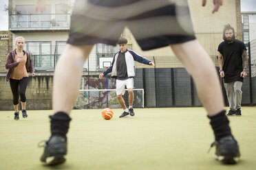 Eine Gruppe Erwachsener spielt Fußball auf einem städtischen Fußballplatz - CUF13063