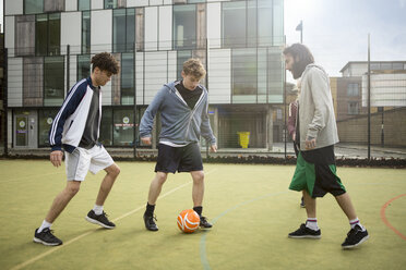 Eine Gruppe Erwachsener spielt Fußball auf einem städtischen Fußballplatz - CUF13066