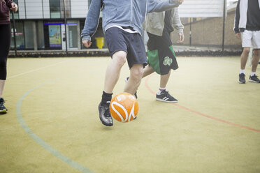 Eine Gruppe Erwachsener spielt Fußball auf einem städtischen Fußballplatz, niedriger Ausschnitt - CUF13067