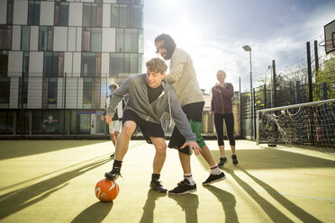 Eine Gruppe Erwachsener spielt Fußball auf einem städtischen Fußballplatz - CUF13068