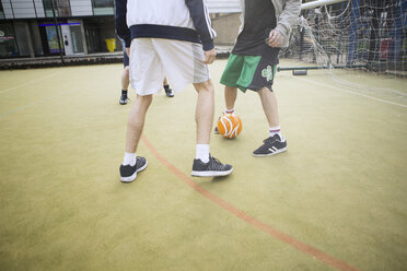 Eine Gruppe Erwachsener spielt Fußball auf einem städtischen Fußballplatz, niedriger Ausschnitt - CUF13070