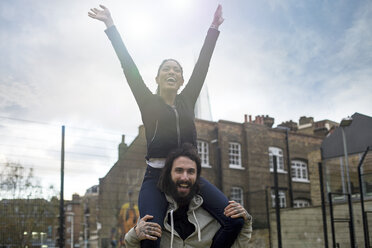 Mid adult man carrying young woman on shoulders, smiling - CUF13080