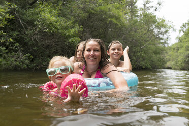 Mutter und Kinder mit aufblasbarem Ring im See, Niceville, Florida, USA - ISF02171