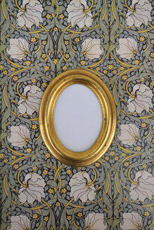 Oval golden picture frame on wallpaper with Art Nouveau floral design - AXF00806