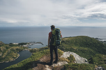 Norwegen,, Lofoten, Moskenesoy, Rucksacktourist auf Klippe stehend, Blick auf den Atlantik - GUSF00762