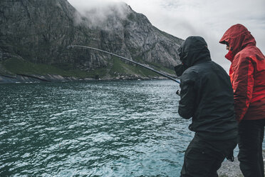 Norway, Lofoten, Moskenesoy, Young men fishing at Horseid Beach - GUSF00780