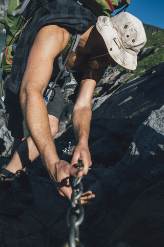 Norwegen, Lofoten, Moskenesoy, Junger Mann beim Wandern in den Bergen, lizenzfreies Stockfoto