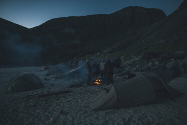 Norwegen, Lofoten, Moskensoy, Gruppe junger Männer am Lagerfeuer am Kvalvika Strand - GUSF00800