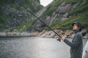 Norway, Lofoten, Moskenesoy, Young man fishing at Krokvatnet - GUSF00815