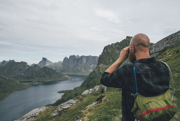 Norwegen, Lofoten, Moskenesoy, Mann schaut über Kjerkefjord - GUSF00819