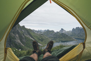 Norwegen, Lofoten, Moskenesoy, Füße eines Mannes, liegend in einem Zelt über dem Kjerkefjord - GUSF00820