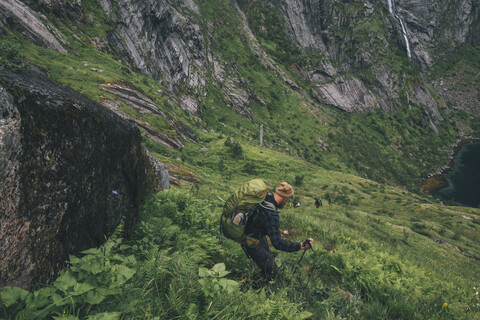 Norwegen, Lofoten, Moskenesoy, Mann wandert bergab, lizenzfreies Stockfoto