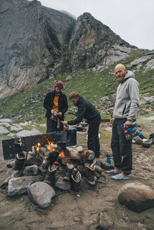 Norwegen, Lofoten, Moskenesoy, Junge Männer machen ein Lagerfeuer am Bunes Strand - GUSF00848