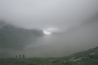 Norway, Lofoten, Moskenesoy, Three men hiking in the fog - GUSF00850