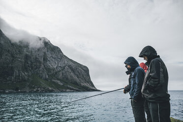 Norway, Lofoten, Moskenesoy, Young men fishing at Horseid Beach - GUSF00863