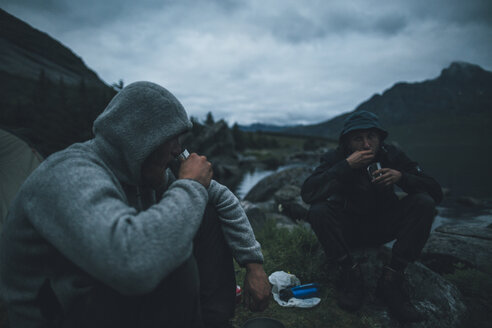 Norwegen, Lofoten, Moskensoy, Junge Männer beim Frühstück am Selfjord - GUSF00873