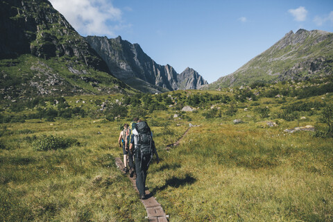 Norwegen, Lofoten, Moskenesoy, Junge Männer wandern am Litljordtinden, lizenzfreies Stockfoto