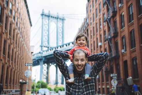 USA, New York, New York City, Vater mit Baby auf den Schultern in Brooklyn mit der Manhattan Bridge im Hintergrund - GEMF02003