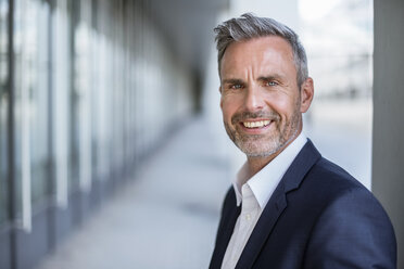 Portrait of laughing businessman with grey hair and beard - DIGF04303