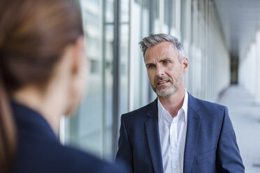 Portrait of sceptical businessman face to face to his business partner - DIGF04307