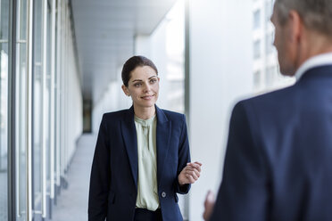 Portrait of smiling businesswoman listening to business partner - DIGF04308