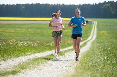 Couple running on field path - DIGF04347