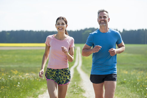 Couple running on field path - DIGF04348