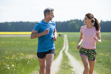 Couple running on field path - DIGF04349