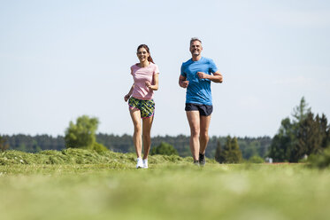 Couple running on field path - DIGF04351