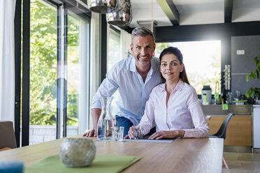 Portrait of smiling couple at table at home - DIGF04427