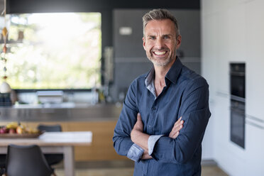 Portait of smiling mature man at home in kitchen - DIGF04451