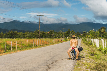 Laos, Vang Vieng, junger Mann mit Fahrrad auf der Straße - AFVF00524