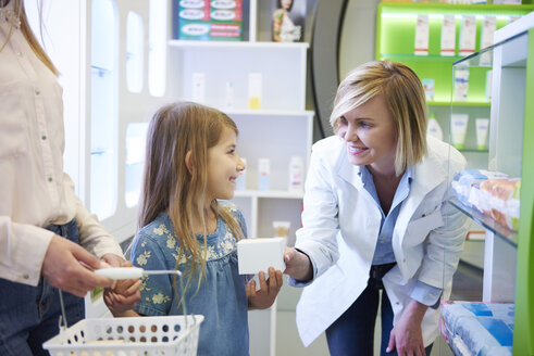 Pharmacist advising mother and daughter in pharmacy - ABIF00411