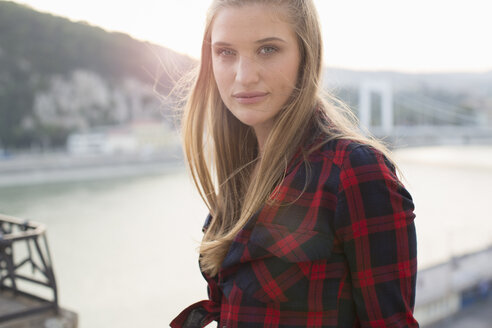 Porträt einer jungen Frau auf einer Dachterrasse am Wasser, Budapest, Ungarn - ISF02190