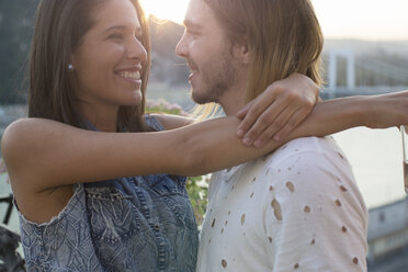 Young couple on waterfront roof terrace, Budapest, Hungary - ISF02192