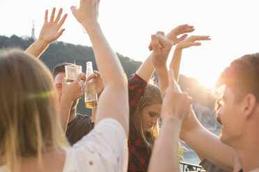 Adult friends dancing at sunset roof terrace party, Budapest, Hungary - ISF02196