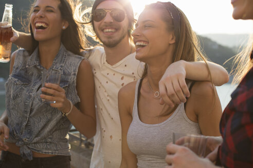 Vier erwachsene Freunde beim Feiern auf der Dachterrasse am Wasser - ISF02200