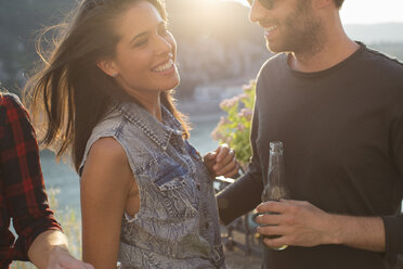 Young couple drinking beer at waterfront party, Budapest, Hungary - ISF02202