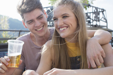 Young couple with drinks at roof terrace party - ISF02222