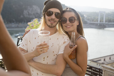 Young couple being photographed at roof terrace party, Budapest, Hungary - ISF02249