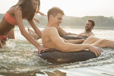 Friends having fun with inflatable ring in river - ISF02279