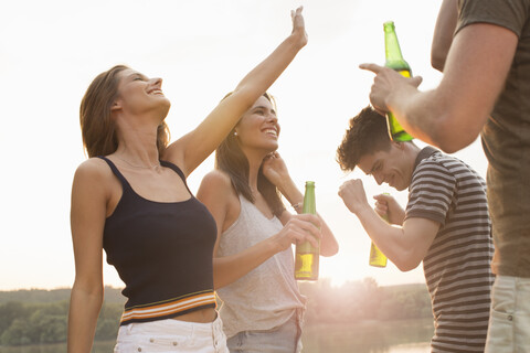 Eine Gruppe von Freunden trinkt und genießt eine Strandparty, lizenzfreies Stockfoto