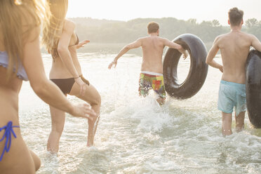 Friends having fun with inflatable ring in river - ISF02295