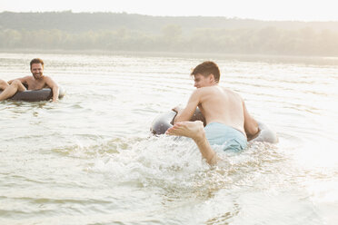 Freunde haben Spaß mit aufblasbarem Ring im Fluss - ISF02297