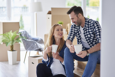 Man and pregnant woman moving into new flat having a coffee break - ABIF00429