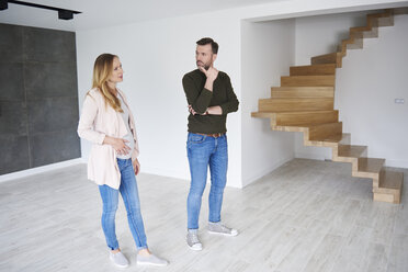 Couple standing in empty flat - ABIF00436